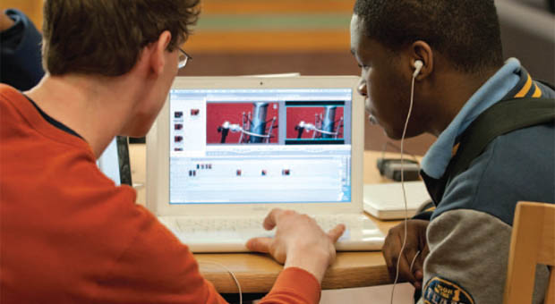 Two young men looking at a laptop screen.