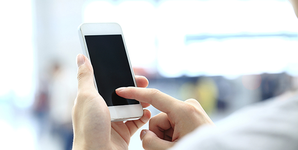 Hands holding and using a touch screen smartphone