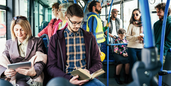 Woman and man reading on crowded bus