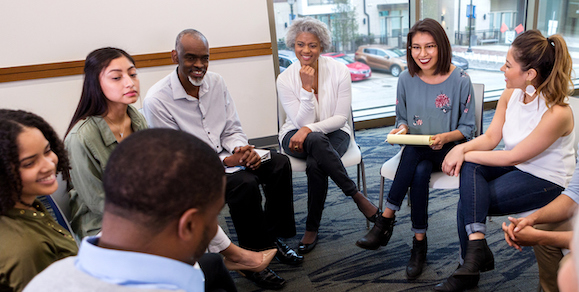 Group of people sitting in a circle laughing