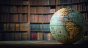 Globe on table in front of bookshelves