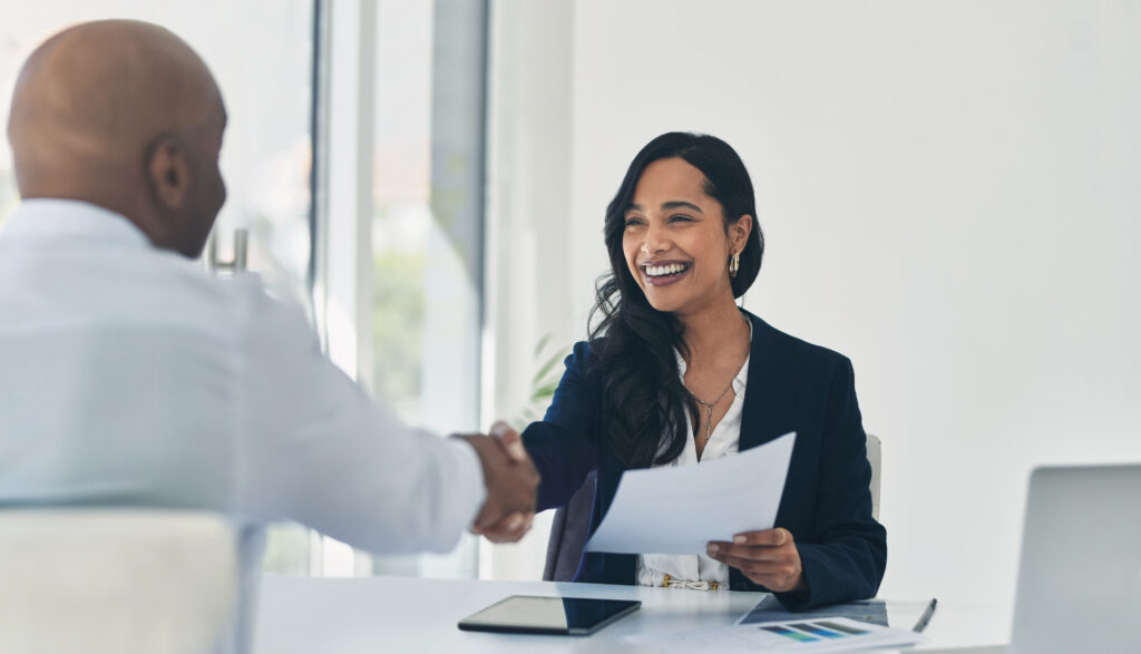 two people seated shaking hands