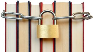 Padlock and chain around group of books