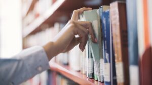 Person removing book from shelf