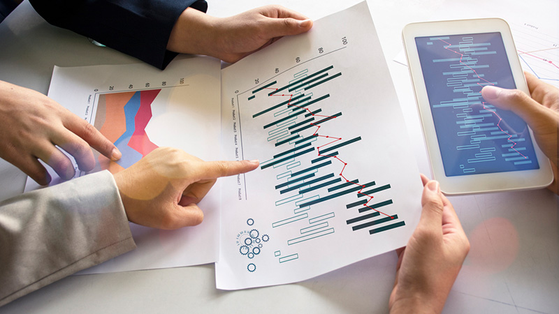 Three people holding data visualizations in different formats.