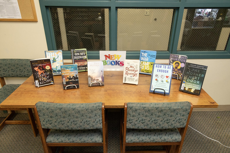 54622854281_f917be94fe_c A table display of new books in a prison library.