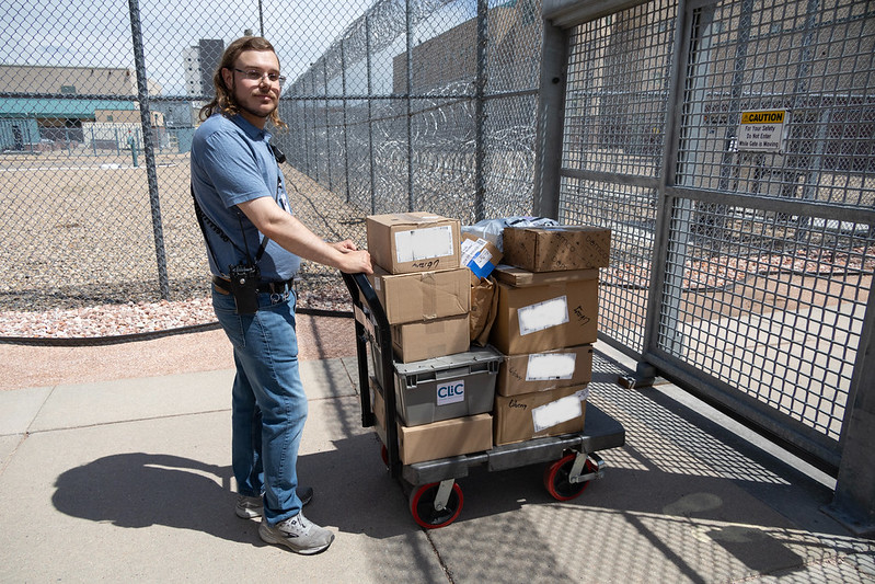 54623063199_b2580bcbef_c A prison library staff member wheeling in a cart of boxes to the prison.