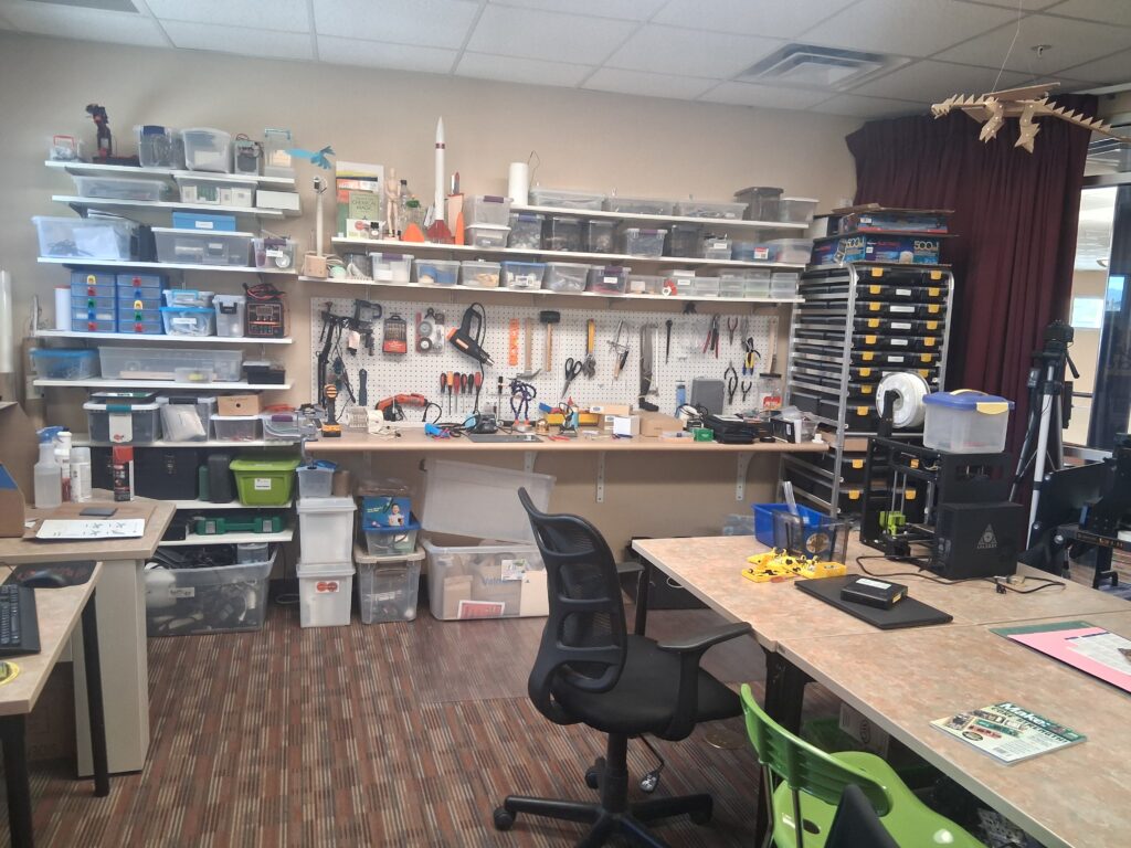 A table, chair, and workbench in the Idea Lab where many tools and materials are stored.